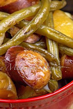 a red bowl filled with green beans and potatoes