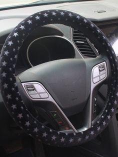 the steering wheel cover is decorated with stars and has a black leather interior, along with white stitching