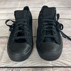 a pair of black sneakers with laces on them