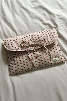 a white and red bag laying on top of a bed