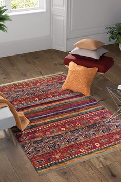 a room with wooden floors and colorful rugs