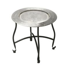 a metal tray sitting on top of a black iron stand with an ornate design in the middle