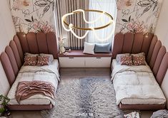 two beds in a room with floral wallpaper on the walls and a round light hanging above them