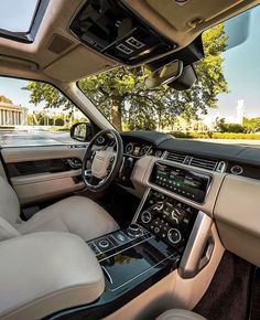 the interior of a car with white leather seats and dashboards, along with an american flag in the background