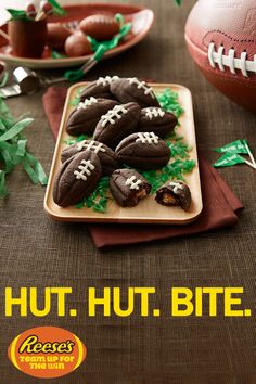 chocolate football cookies with green sprinkles are on a plate next to a football