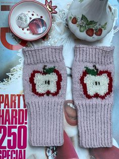 two knitted mitts with strawberrys on them and the words party hard 250 special