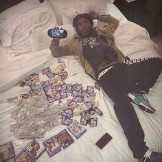 a man laying on top of a bed with lots of cards and cell phones next to him