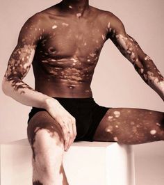 a man sitting on top of a white box covered in brown paint and sprinkles