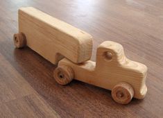 a wooden toy truck sitting on top of a hard wood floor