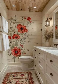 a bathroom decorated in white with red flowers on the wall and wooden ceilinging, along with an area rug