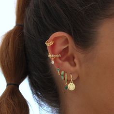 a close up of a person wearing ear rings with beads and charms on their ears