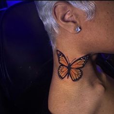 a close up of a person with a butterfly tattoo on their neck and behind the ear