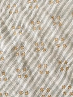 the fabric is white and gold with small flowers on it's side, as well as stripes