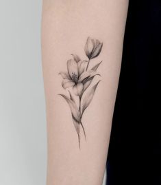 a black and white flower tattoo on the arm