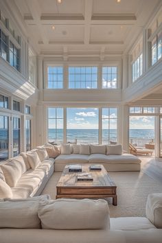 a living room with couches and windows overlooking the ocean is pictured in this image