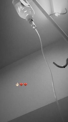 three red hearts hanging from the ceiling next to a light fixture with an electric cord