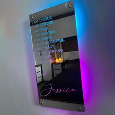 a bathroom mirror that has some writing on the side of it with lights around it