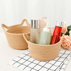 two baskets filled with personal care items on top of a white table next to flowers