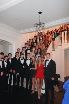 a group of people in tuxedos posing for a photo