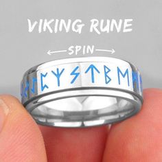 a person holding a ring with the words viking rune spin in blue on it