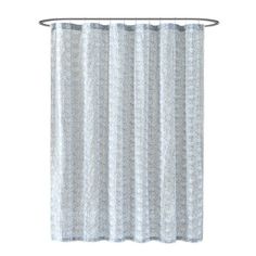 a white shower curtain hanging on a metal rod