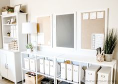 a white desk with many drawers and pictures on the wall