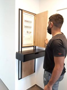 a man standing in front of a desk with an open cabinet