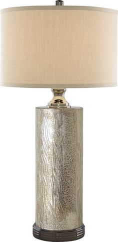 a silver lamp with a beige shade on it's side and a white background