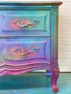 a purple and blue dresser sitting on top of a floor