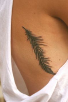 a woman's stomach with a feather tattoo on her belly and the back of her breast