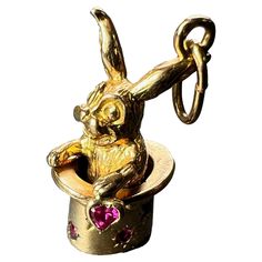 A French 18 karat (18K) yellow gold charm pendant designed as a magician’s top hat set with eight round rubies, containing a moving rabbit holding a ruby heart. Stamped with the eagle's head for 18 karat gold and French manufacture. Dimensions: 2.4 x 1.2 x 1.1 cm (not including jump ring) Weight: 6.11 grams (Chain not included) French Rabbit, Magician Hat, Jewelry Mood Board, Ruby Heart, Eagle Head, Hat Set, Pendant Design, Top Hat, Gold Charm