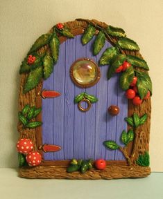 a purple fairy door with green leaves and mushrooms on the outside, surrounded by red berries