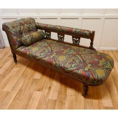 an ornately decorated chaise lounge on wooden floors