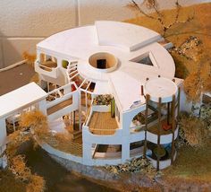 a model of a house with trees and bushes around it