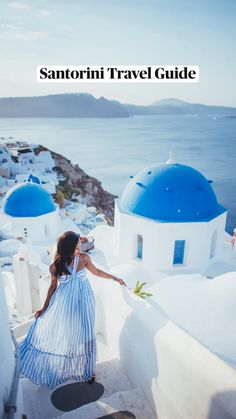 a woman in a blue and white dress is standing on the edge of a building