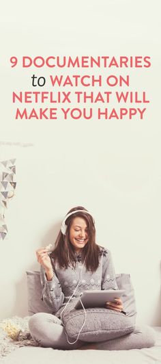 a woman sitting on top of a bed wearing headphones and using a tablet computer