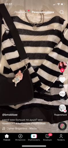 a black and white striped sweater with a small bag on the bottom, sitting next to it