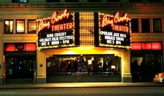 the theater is lit up at night with christmas lights