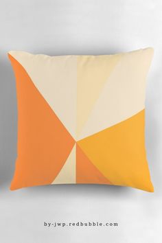 an orange, yellow and white pillow on a gray background