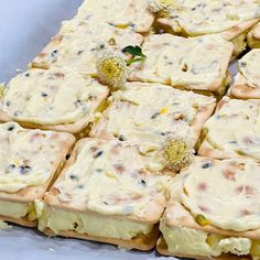 there are many square pieces of food on the table with white frosting and sprinkles