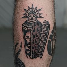 a man's leg with a black and white tattoo design on it, featuring a skull holding a vase