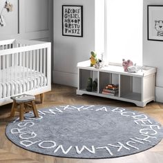 a baby's room with a white crib and gray rug