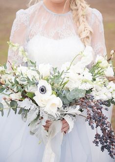 a bride holding a bouquet of flowers in her hands