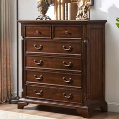 a wooden dresser sitting in front of a mirror