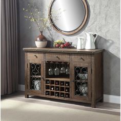 a wooden sideboard with wine bottles and vases on it in front of a mirror