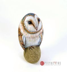 an owl figurine sitting on top of a rock