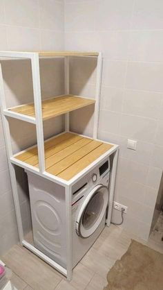 a washer and dryer in a room with white tile walls, flooring and shelves