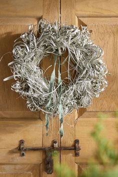 a close up of a wreath on a wooden door with metal bars attached to it