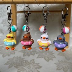 four key chains with different colored rubber ducks on them