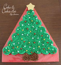 a christmas tree shaped cupcake with green icing on top and chocolate pretzels in the middle